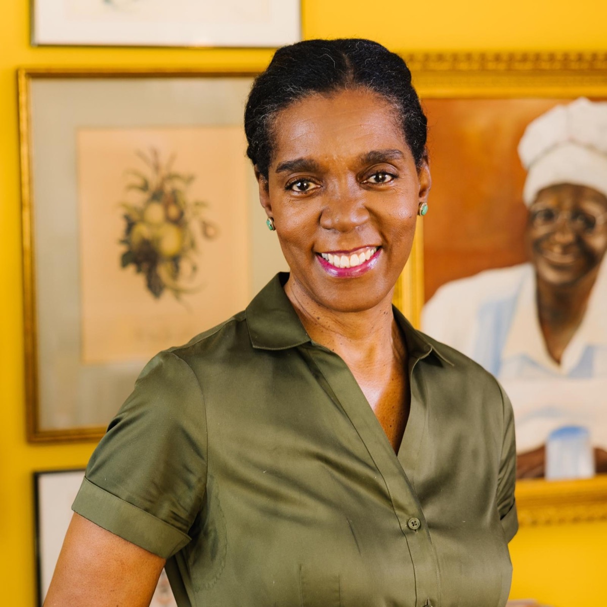 Photo of Spring Council smiling in front of a yellow wall hung with framed art